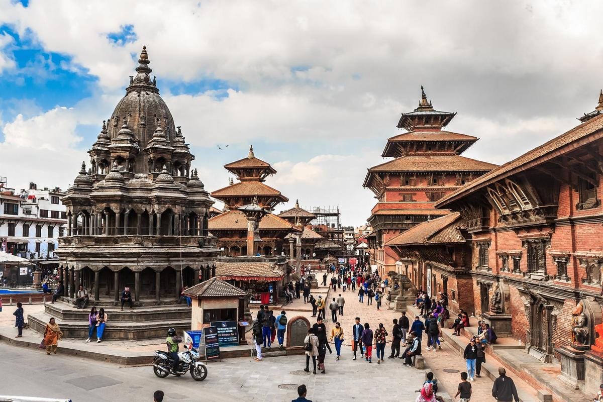 Alt text: Vibrant Kathmandu at dawn, with bustling streets, intricate architecture, and Himalayan backdrop.