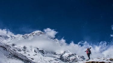 Alt text: Hyperrealistic photo of trekkers with map in Nepal's Himalayas at sunrise, capturing serenity and grandeur.