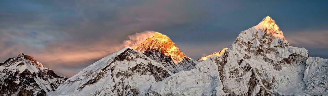 Climber ready to ascend Mount Everest in crisp morning light, amid increased fees.